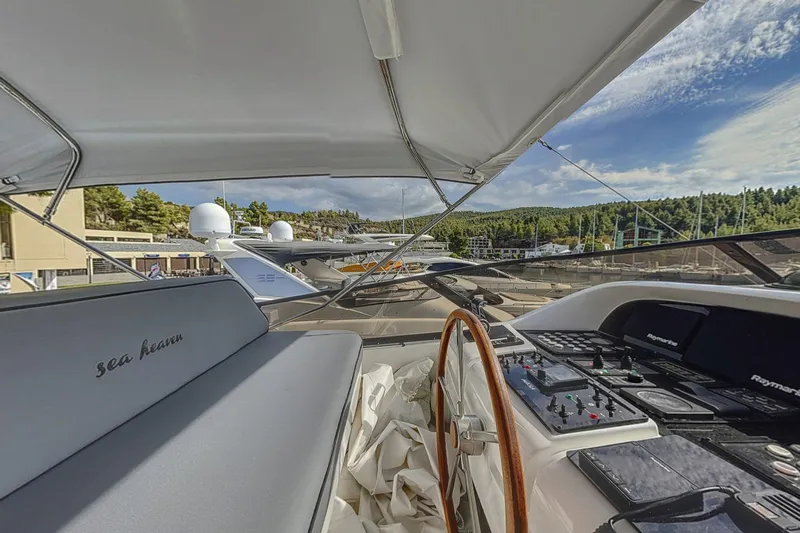  Yacht Photos Pics Luxurious 2002 Maiora 20 yacht cockpit with steering wheel and control panel, docked in scenic marina.