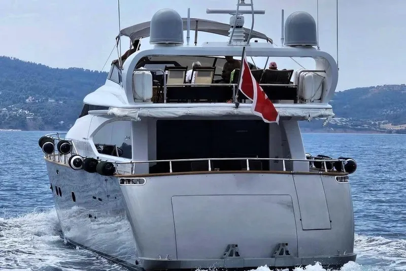  Yacht Photos Pics Luxurious 2002 Maiora 20 yacht cruising on serene waters, with scenic coastal backdrop.