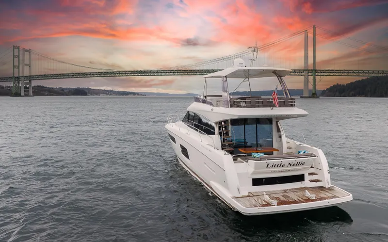 Little Nellie Yacht Photos Pics Prestige 560 yacht cruising under a bridge at sunset, 2017 model.