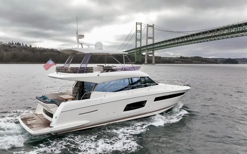 Little Nellie Yacht Photos Pics 2017 Prestige 560 yacht cruising near a large bridge on a cloudy day.