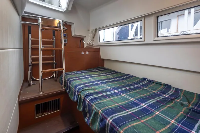 Little Nellie Yacht Photos Pics Cabin interior of 2017 Prestige 560 yacht with plaid bedspread and ladder.