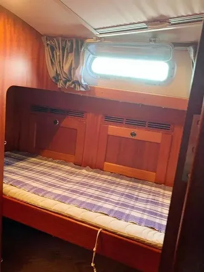 Yacht Photos Pics Cozy cabin interior of 2006 Hallberg-Rassy 48 MK sailboat with wooden finish and window.