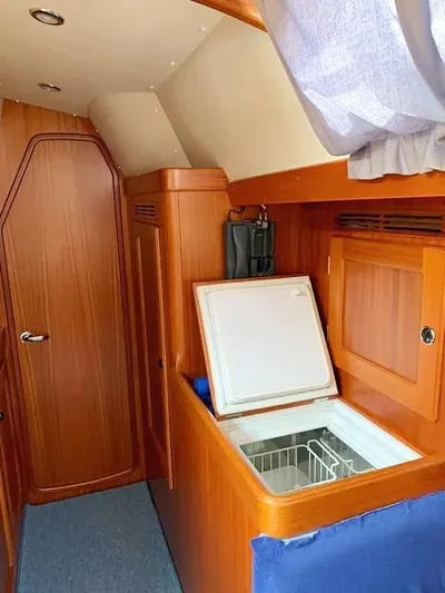  Yacht Photos Pics Interior of 2006 Hallberg-Rassy 48 MK yacht with wooden cabinetry and open storage compartment.