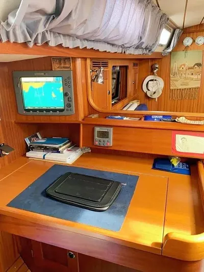  Yacht Photos Pics Navigation station inside 2006 Hallberg-Rassy 48 MK yacht with chart plotter and wooden cabinetry.