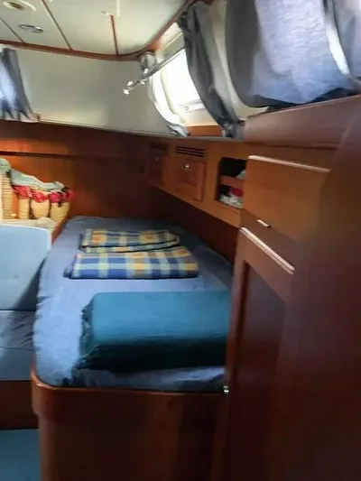  Yacht Photos Pics Interior cabin of 2006 Hallberg-Rassy 48 MK sailboat with cozy bedding and wooden finish.