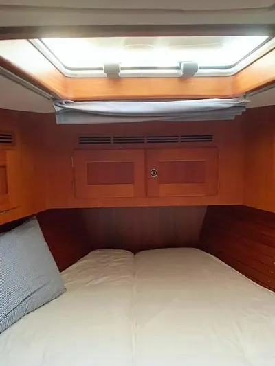  Yacht Photos Pics Cozy cabin interior of 2006 Hallberg-Rassy 48 MK sailboat with wooden finish and skylight.