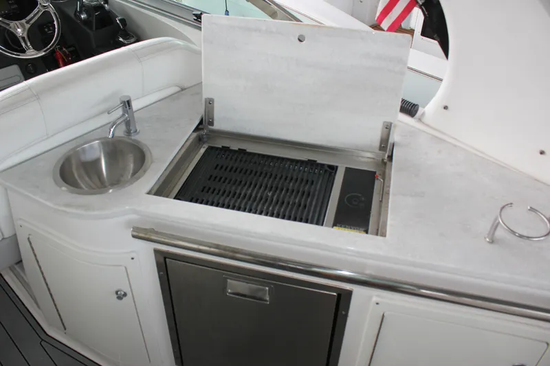  Yacht Photos Pics 2021 Regal 33 XO boat kitchenette with sink, grill, and storage.