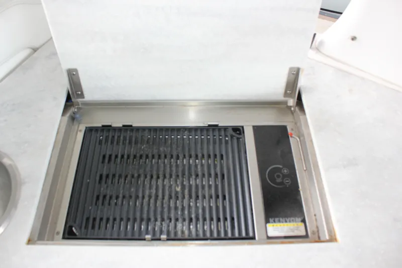  Yacht Photos Pics Built-in grill on 2021 Regal 33 XO boat, featuring a Kenyon electric cooktop.