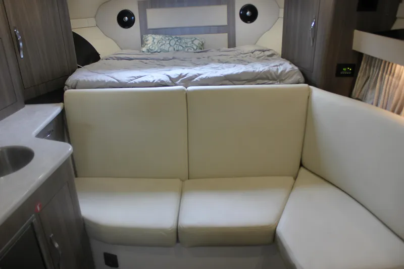  Yacht Photos Pics Interior of 2021 Regal 33 XO boat with bed, sofa, and kitchenette.