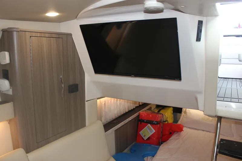  Yacht Photos Pics Interior of 2021 Regal 33 XO boat with TV and storage area.