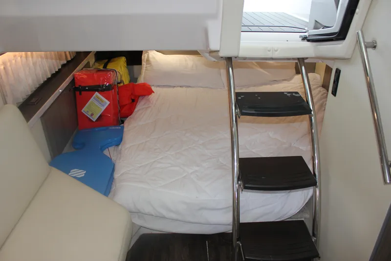  Yacht Photos Pics 2021 Regal 33 XO cabin interior with bed, ladder, and life jackets.