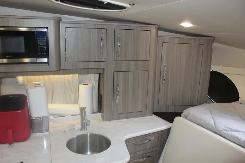  Yacht Photos Pics 2021 Regal 33 XO yacht interior with modern kitchen and cozy sleeping area.
