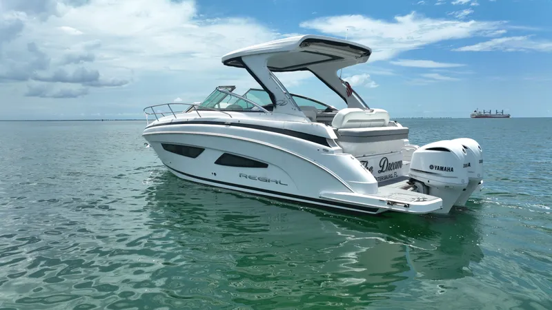  Yacht Photos Pics 2021 Regal 33 XO boat on calm water under a clear sky.