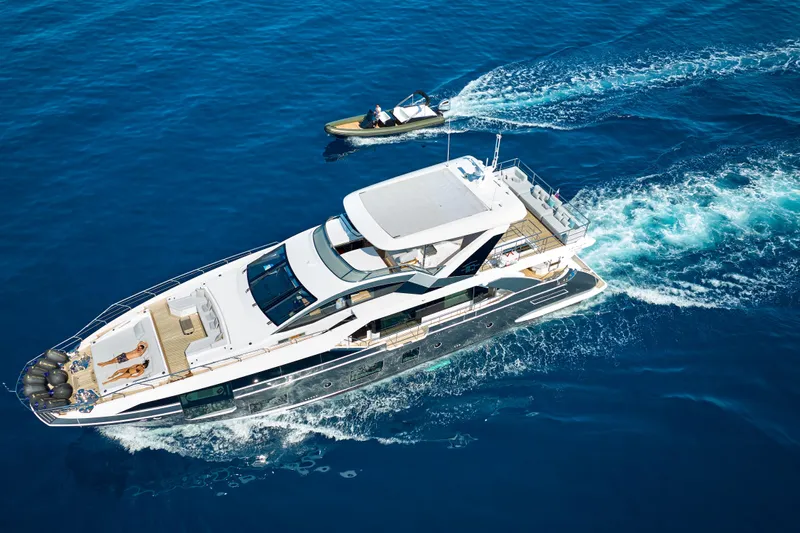 Aluminia Too Yacht Photos Pics Azimut Grande 27M 2024 luxury yacht cruising with a small boat nearby.