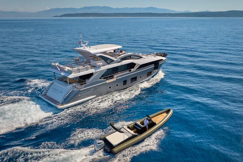 Aluminia Too Yacht Photos Pics 2024 Azimut Grande 27M yacht cruising alongside a smaller boat on open sea.