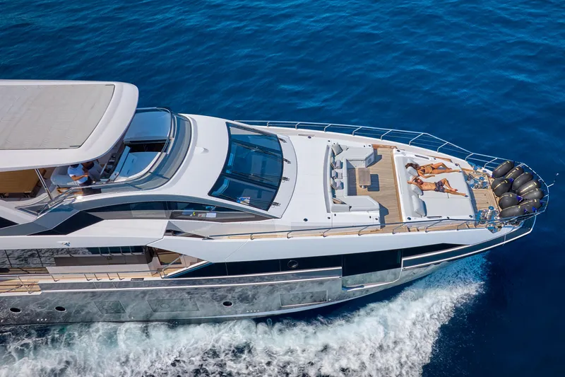 Aluminia Too Yacht Photos Pics 2024 Azimut Grande 27M yacht cruising with sunbathers on deck, surrounded by blue ocean.