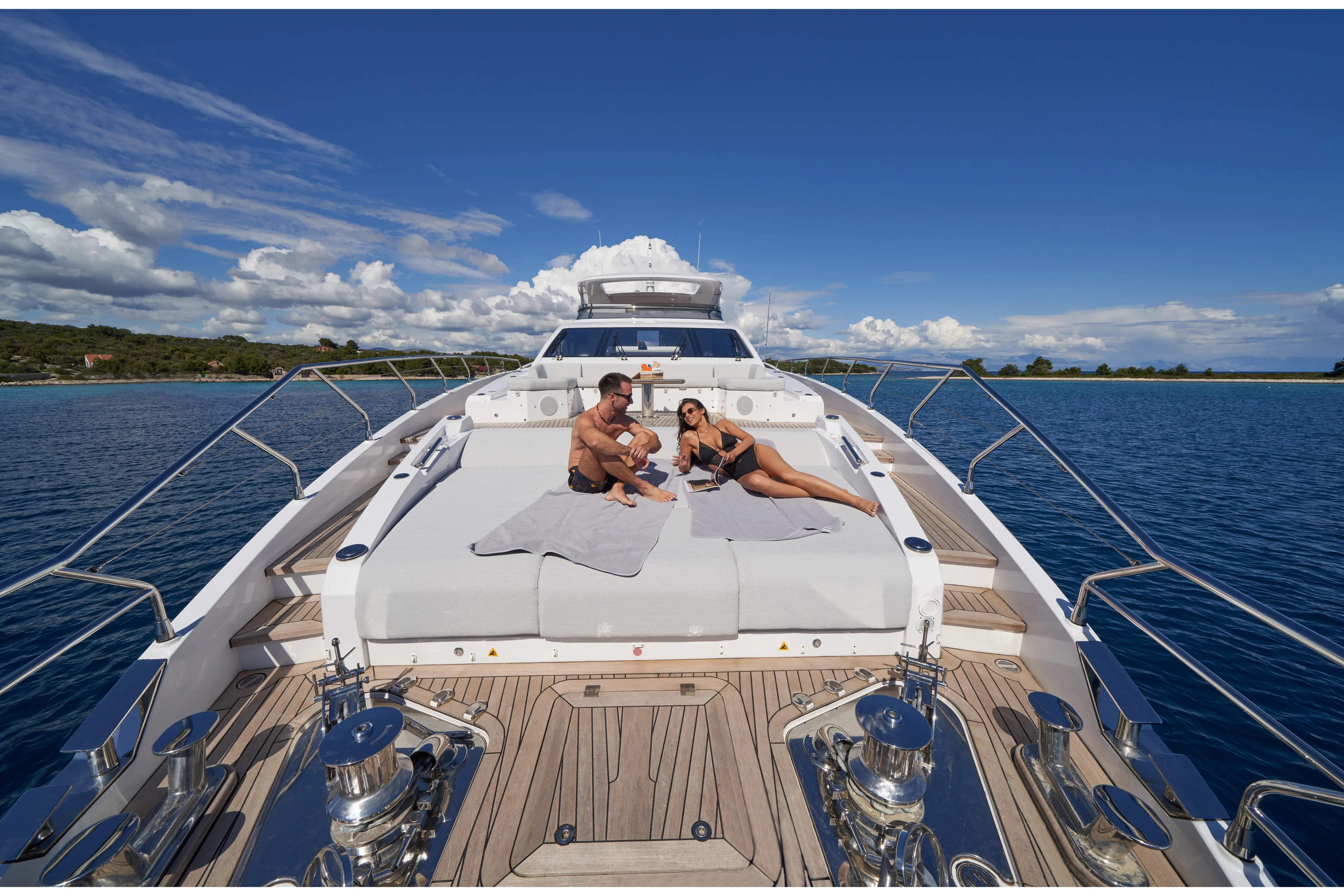 Aluminia Too Yacht Photos Pics Couple relaxing on Azimut Grande 27M yacht, 2024 model, with ocean and sky backdrop.