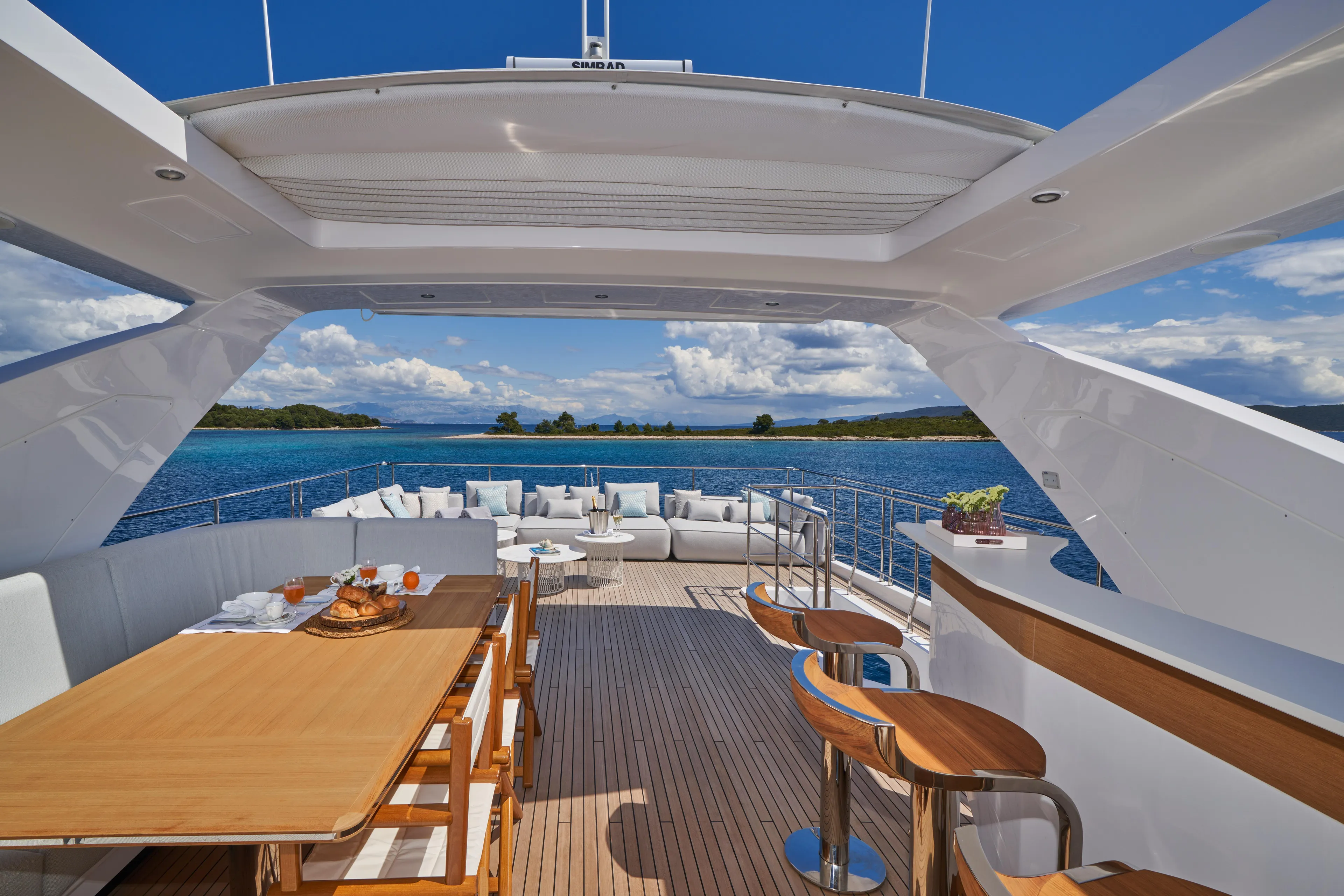 Aluminia Too Yacht Photos Pics Luxurious 2024 Azimut Grande 27M yacht deck with dining area and ocean view.