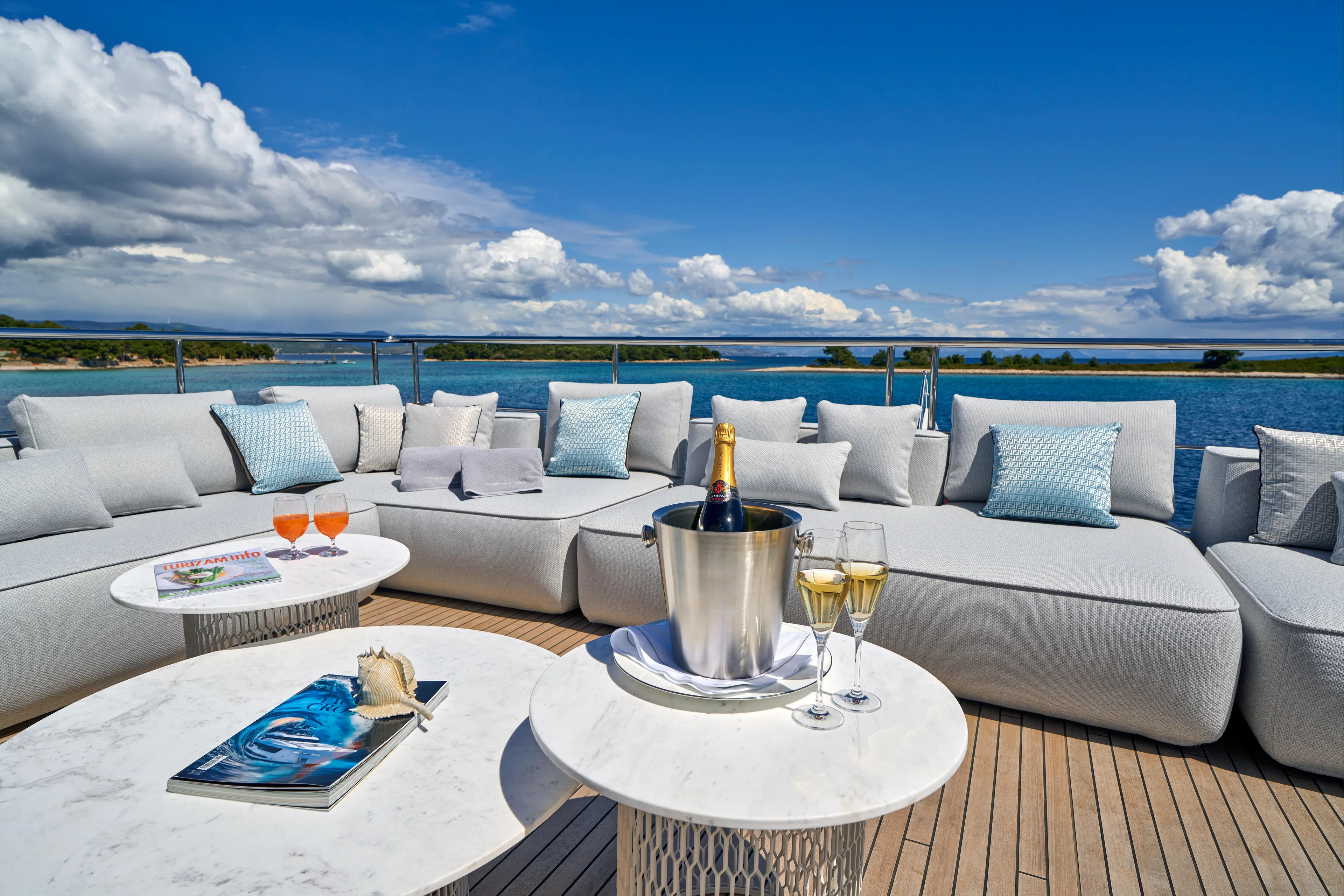 Aluminia Too Yacht Photos Pics Luxurious Azimut Grande 27M yacht deck with elegant seating, champagne, and ocean view, 2024 model.