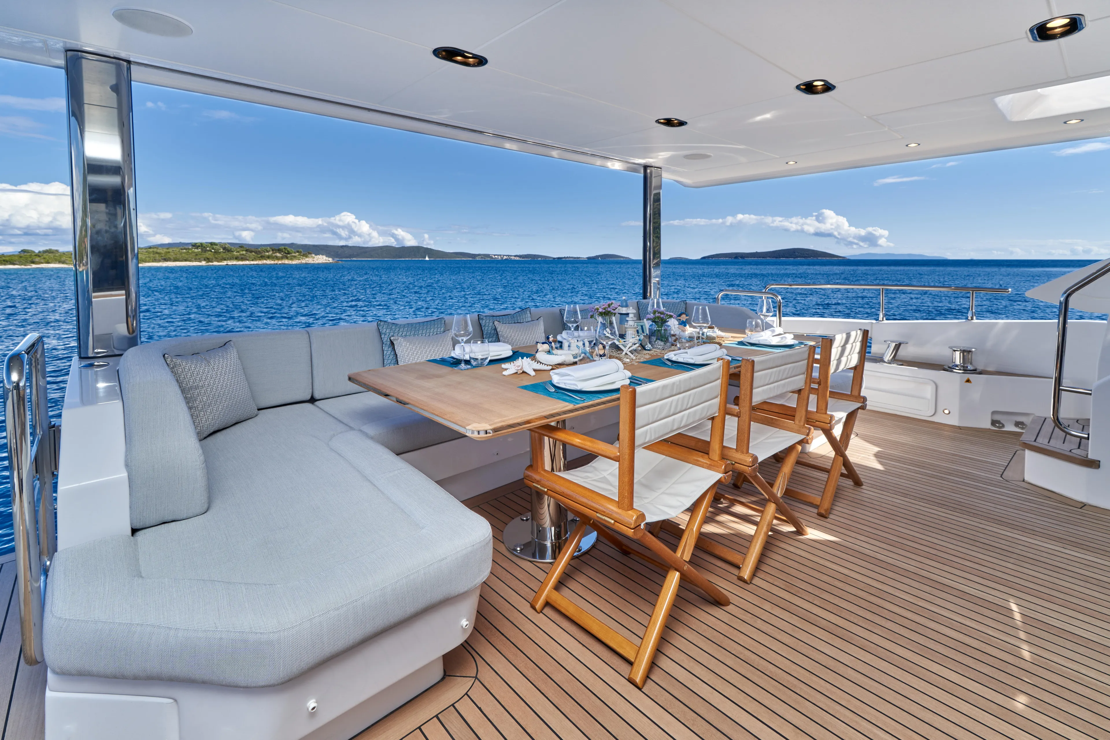 Aluminia Too Yacht Photos Pics Luxurious 2024 Azimut Grande 27M yacht deck with elegant dining setup and ocean view.