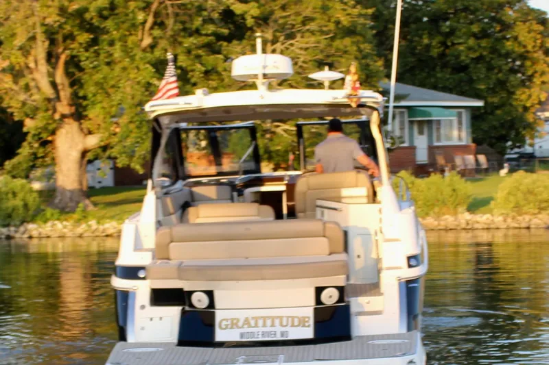 Gratitude Yacht Photos Pics 2015 Regal 35 Sport Coupe boat on water, rear view, with American flags.