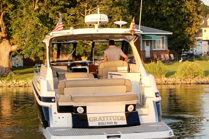 Gratitude Yacht Photos Pics 2015 Regal 35 Sport Coupe boat on water near a lakeside house.