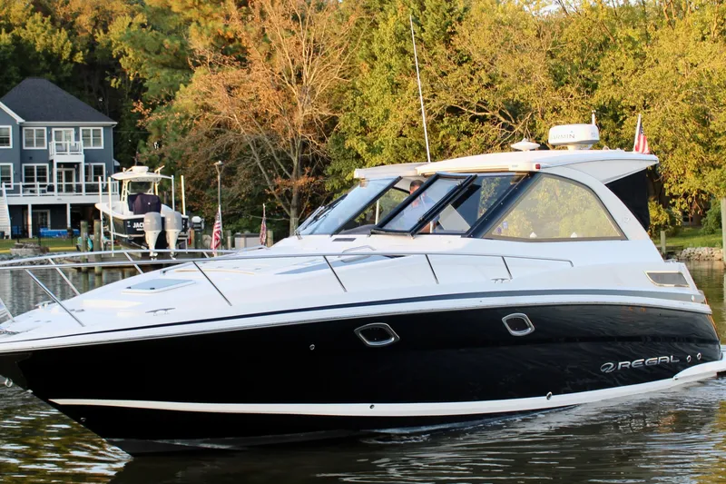 Gratitude Yacht Photos Pics 2015 Regal 35 Sport Coupe boat on a serene lake near a house.