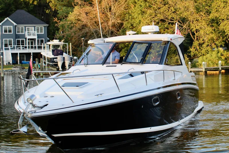 Gratitude Yacht Photos Pics 2015 Regal 35 Sport Coupe cruising on a serene lake near waterfront homes.
