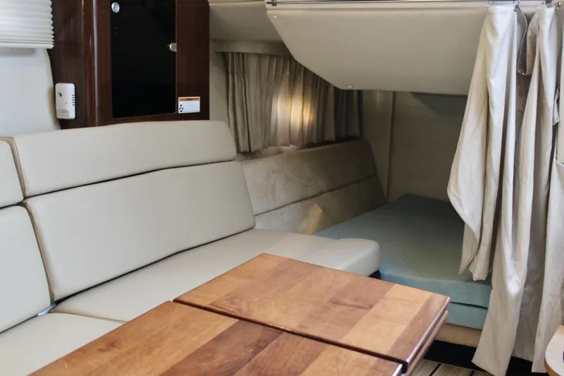 Gratitude Yacht Photos Pics Interior of 2015 Regal 35 Sport Coupe with seating and wooden table.