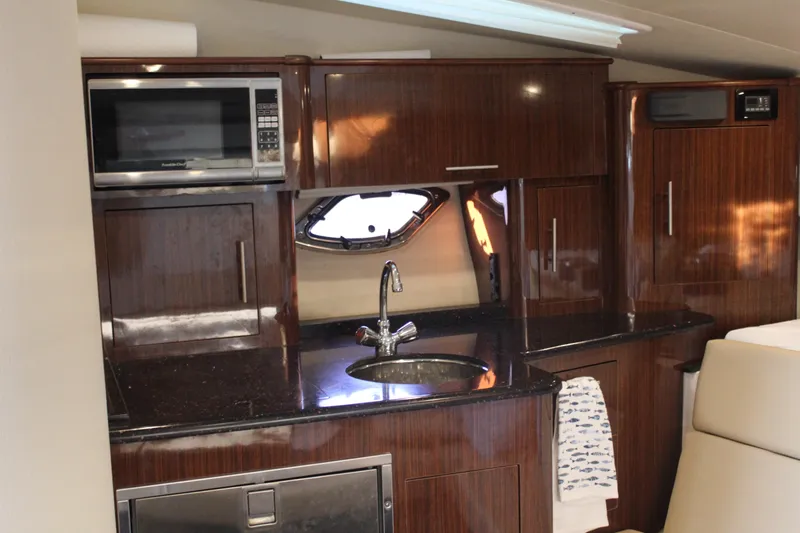 Gratitude Yacht Photos Pics Luxurious kitchen interior of 2015 Regal 35 Sport Coupe with wood cabinetry and modern appliances.