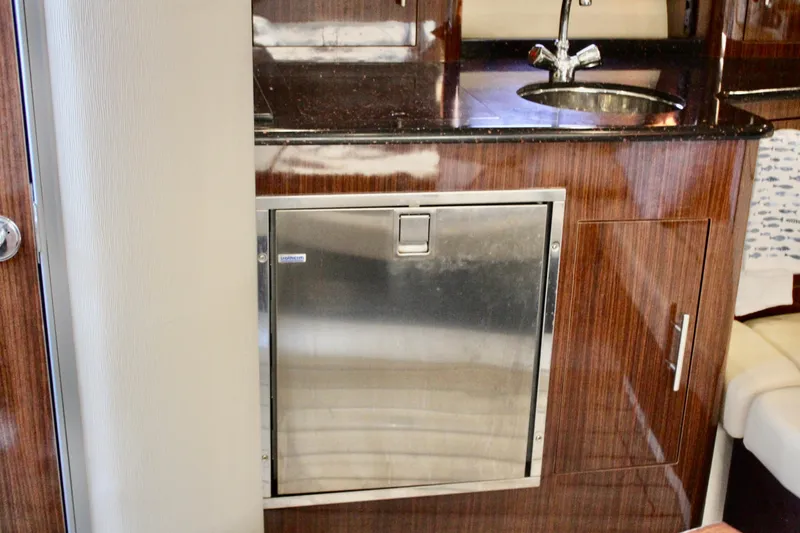 Gratitude Yacht Photos Pics 2015 Regal 35 Sport Coupe interior with wood cabinetry and stainless steel fridge.