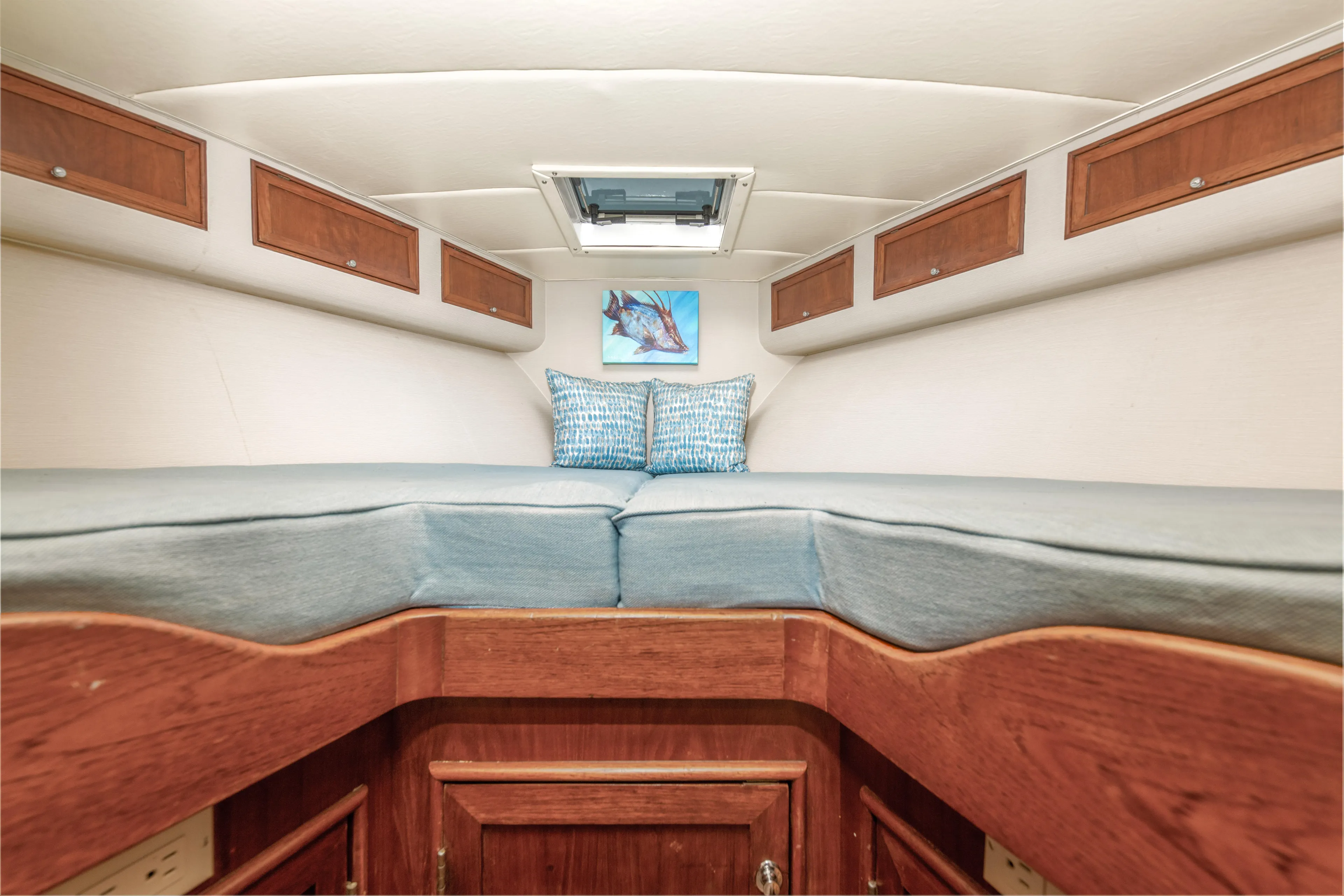 Megabite Yacht Photos Pics Interior cabin of 1984 Custom Carolina Scarborough boat with cozy bedding and wooden storage.