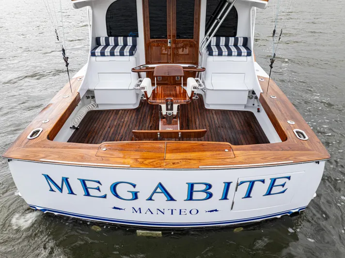 Megabite Yacht Photos Pics 1984 Custom Carolina Scarborough boat "Megabite" with wooden deck and seating, docked on water.