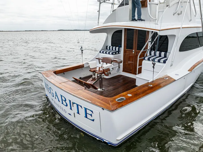 Megabite Yacht Photos Pics 1984 Custom Carolina Scarborough boat on water, featuring wooden deck and striped seating.