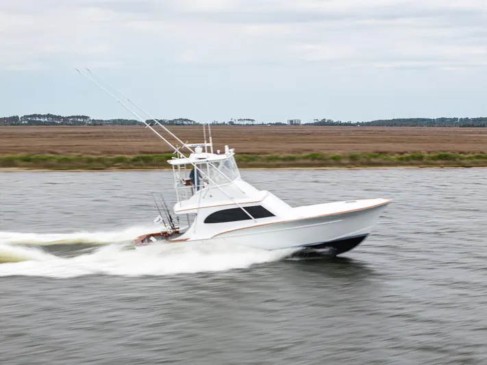 Megabite Yacht Photos Pics 1984 Custom Carolina Scarborough boat cruising on a river with scenic background.