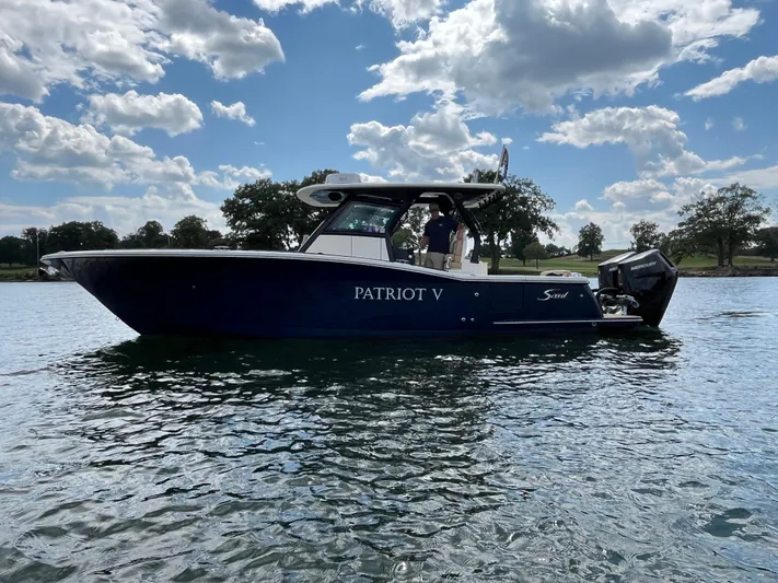  Yacht Photos Pics 2024 Scout 330 LXF boat on water under blue sky.