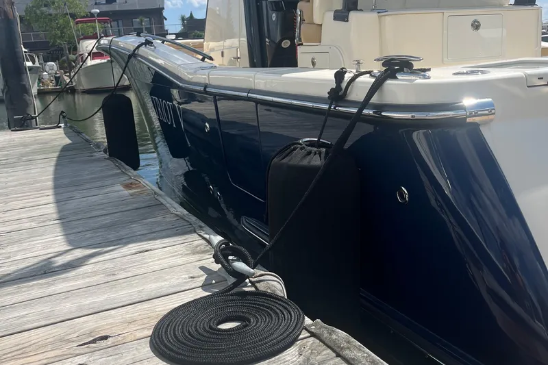  Yacht Photos Pics 2024 Scout 330 LXF boat docked, showcasing sleek design and modern features.