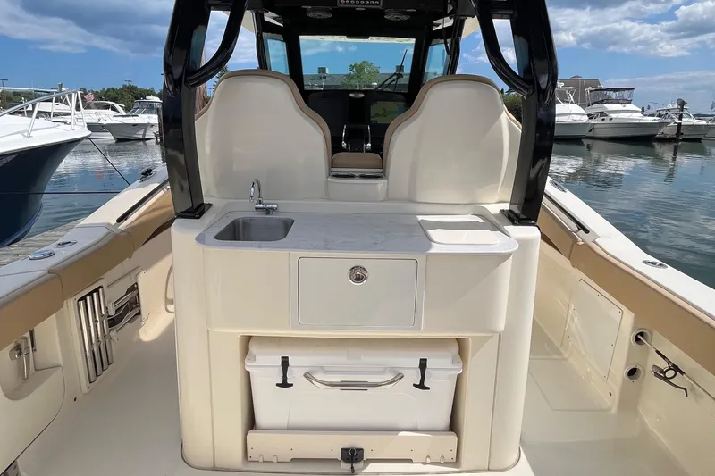  Yacht Photos Pics 2024 Scout 330 LXF boat interior with sink and storage, docked at marina.