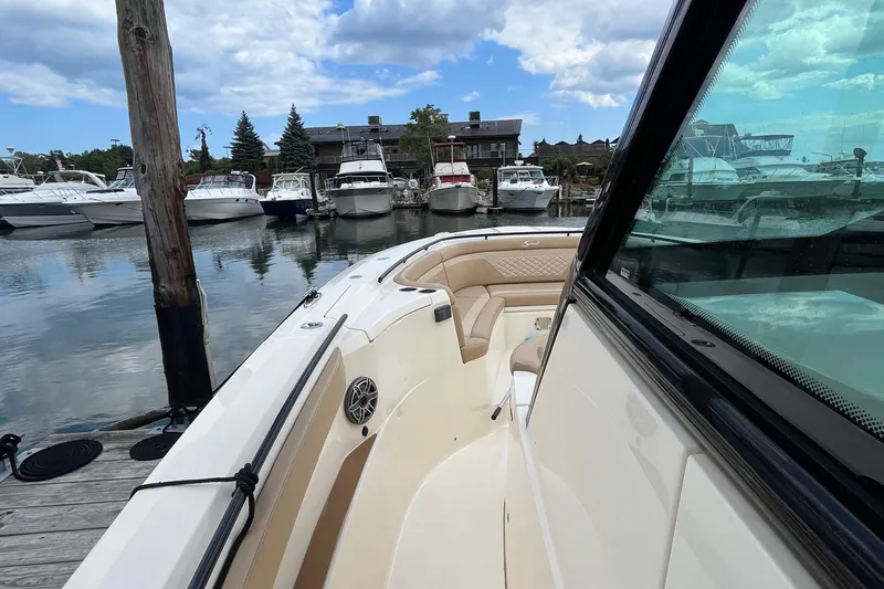  Yacht Photos Pics 2024 Scout 330 LXF boat docked in marina, surrounded by other boats.