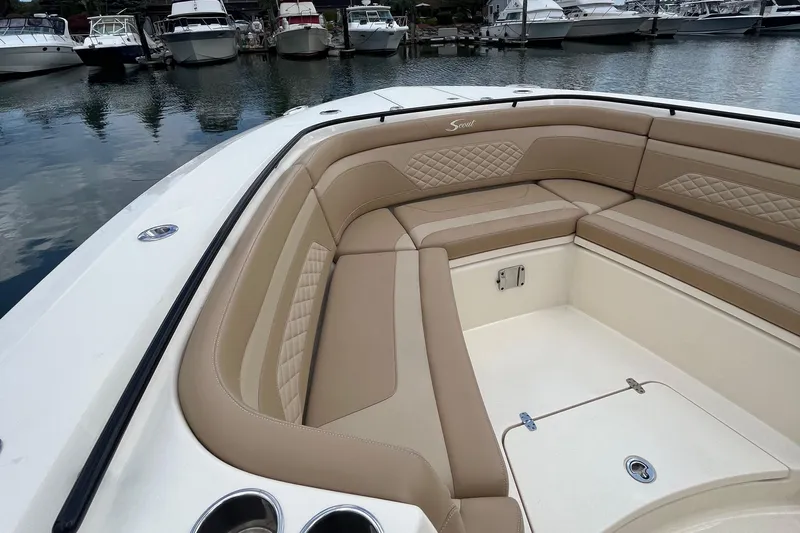 Yacht Photos Pics 2024 Scout 330 LXF boat with luxurious tan seating in a marina.