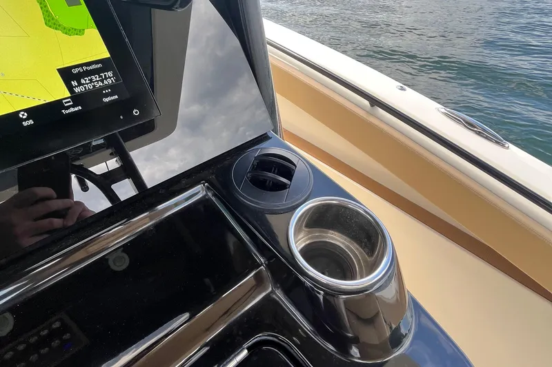  Yacht Photos Pics 2024 Scout 330 LXF boat console with GPS and cup holder by the water.