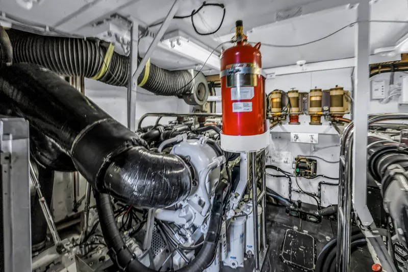  Yacht Photos Pics Engine room of 2000 Neptunus 65 Flybridge yacht with visible machinery and fire extinguisher.