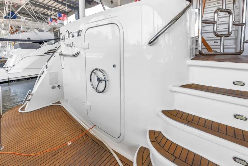  Yacht Photos Pics 2000 Neptunus 65 Flybridge yacht with teak deck and elegant staircase in marina.