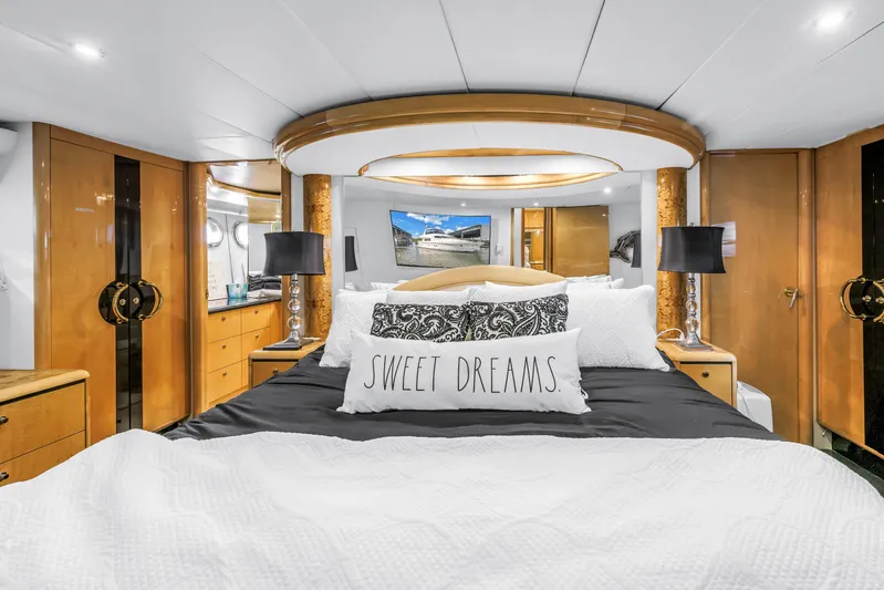  Yacht Photos Pics Luxurious bedroom interior of 2000 Neptunus 65 Flybridge yacht with elegant decor and cozy bedding.