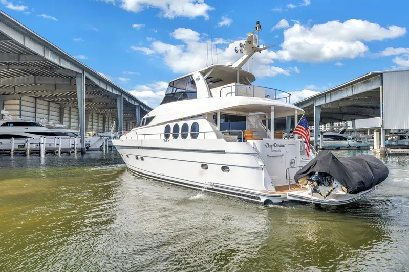  Yacht Photos Pics Luxury Neptunus 65 Flybridge yacht docked, 2000 model, with American flag, under blue sky.