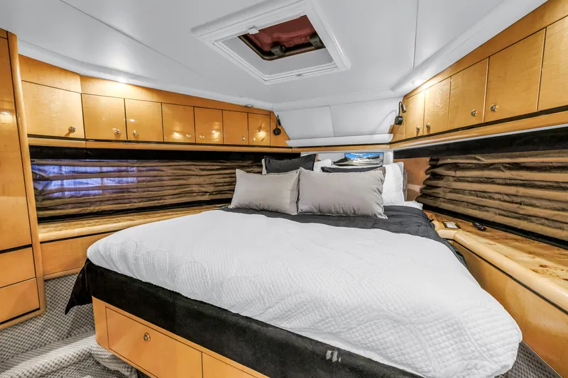  Yacht Photos Pics Luxurious bedroom interior of 2000 Neptunus 65 Flybridge yacht with elegant wood cabinetry.