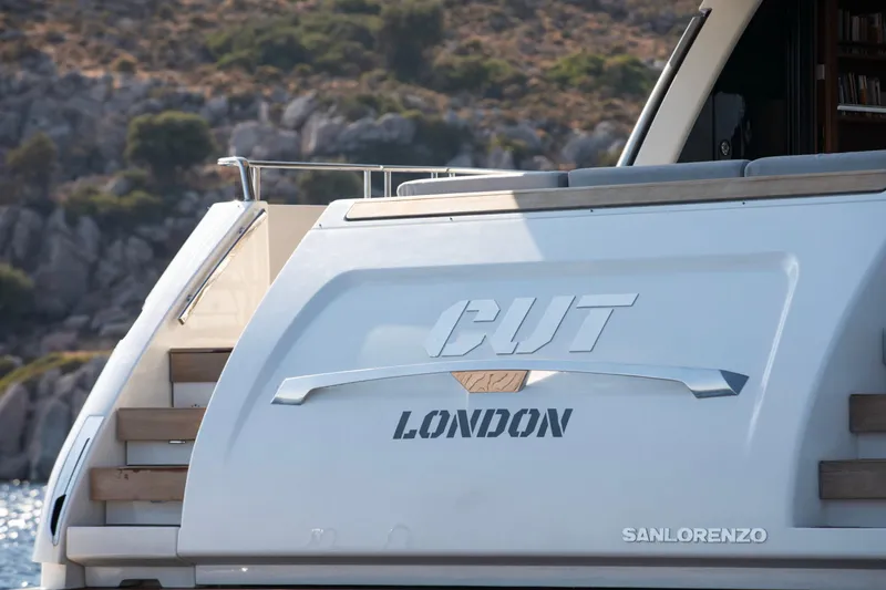  Yacht Photos Pics 2017 Sanlorenzo SL86 yacht with "CUT LONDON" text, docked near rocky shoreline.
