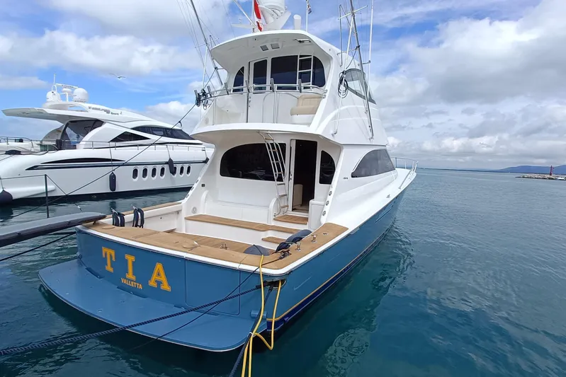 Tia Yacht Photos Pics 2017 Viking 62 Enclosed Bridge yacht docked in marina, featuring sleek design and spacious deck.