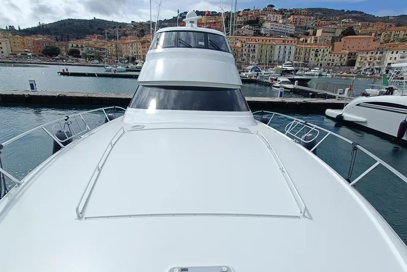 Tia Yacht Photos Pics 2017 Viking 62 Enclosed Bridge yacht docked in a scenic marina.