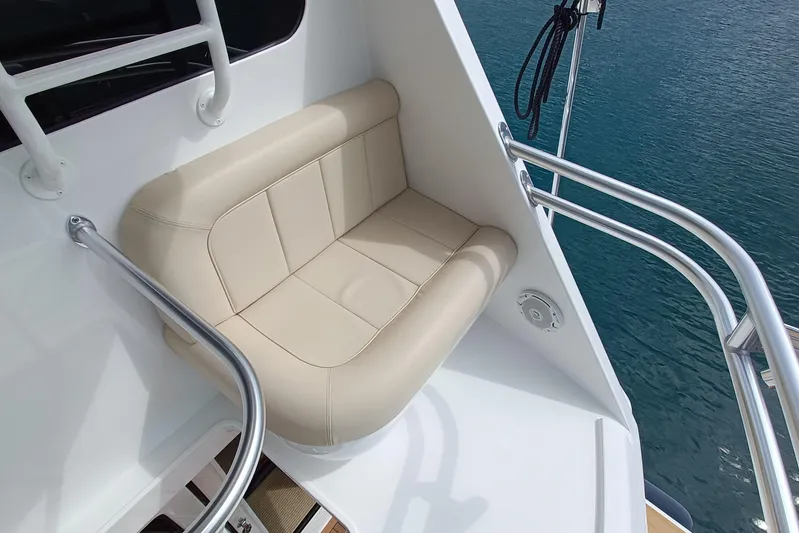 Tia Yacht Photos Pics Luxurious seating on 2017 Viking 62 Enclosed Bridge yacht, overlooking serene water.